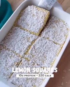 lemon squares in a white baking dish on a wooden table