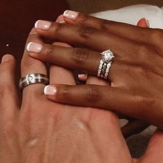 two people holding hands with wedding rings on their fingers and one woman's hand