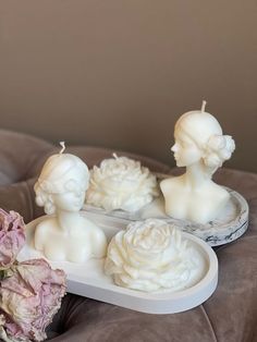 three candles are sitting on a tray with flowers