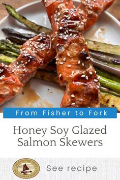 salmon and asparagus on a white plate with sesame seeds in the foreground text reads from fishereto fork honey soy glazed salmon skewers