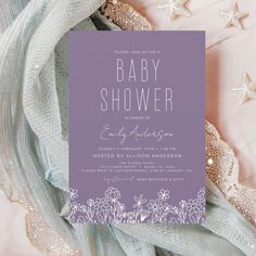 a baby shower is shown with purple and white flowers on the bottom, and silver stars in the background