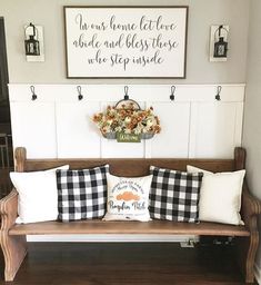 a wooden bench with pillows on it in front of a sign that says, i love you