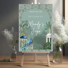 a welcome sign with a peacock on it and flowers in vases next to it