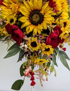 a bouquet of sunflowers and roses in a vase