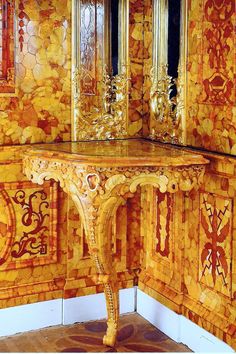 an ornately decorated table in the corner of a room with gold and red tiles