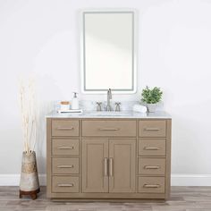 a bathroom vanity with two sinks and a mirror on the wall above it in a white room