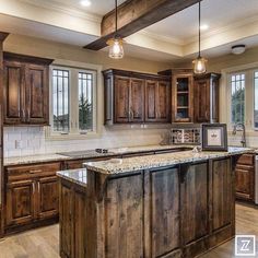 a large kitchen with wooden cabinets and marble counter tops, along with an island in the middle