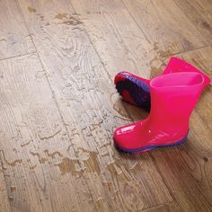 a pair of pink rain boots sitting on top of a wooden floor