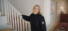 a woman standing next to a stair case