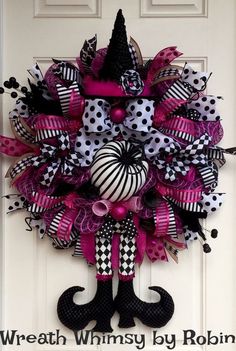 the wreath is decorated with black, white and pink ribbon decorations on it's front door