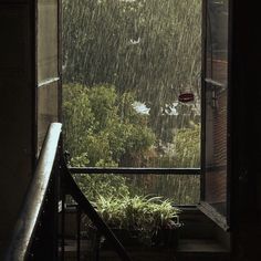 an open window with rain falling down on it