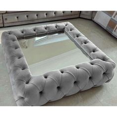 a large square glass table with buttons on the top and bottom, in front of a couch