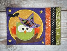 an owl with a witches hat on it's head sitting in front of a wooden background