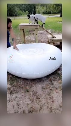 a woman kneeling down next to a giant frisbee