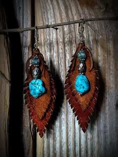 Rustic leather earrings! "These rustic brown leather and bohemian turquoise stone earrings beautifully blend earthy charm with a touch of bohemian flair.... The warm tones of the leather provide a natural, rustic backdrop, while the vibrant turquoise stones add a pop of color and a unique, artistic touch Perfect for adding a hint of boho chic to any outfit, these earrings are versatile and stylish, ideal for casual wear or dressing up for a special occasion." The actual earring measures 3 1/2" i Artisan Brown Earrings With Natural Stones, Brown Adjustable Earrings With Natural Stones, Handmade Leather Turquoise Earrings, Bohemian Hand Tooled Teardrop Earrings, Bohemian Turquoise Leather Earrings, Bohemian Hand-tooled Leather Earrings, Hand Tooled Teardrop Bohemian Earrings, Handmade Turquoise Leather Earrings, Bohemian Teardrop Hand Tooled Earrings