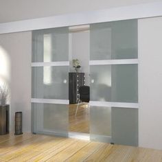 an empty room with sliding glass doors in the middle and wood flooring on the other side