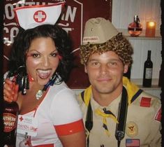 a man and woman dressed up in costume posing for a photo with beer bottles behind them