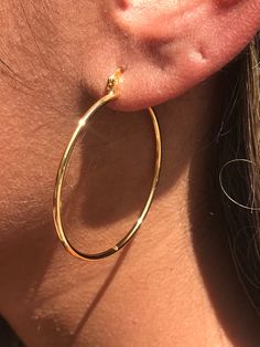 18kt Gold Filled Hoop Earrings Hoop Size: 40mm Width: 1.5mm Clasp: Hinged Material: 18 Karat Gold Filled, Hypoallergenic. Tarnish Resistant. Gold-filled does not de-laminate or peel like Gold plated Jewelry nor does it tarnish as readily as silver. Generally speaking, gold filled is better quality and will have a much longer lasting color than plated jewelry. We recommend keeping abrasive chemicals away from the jewelry for the items to last. Thank you for visiting and supporting our small busin