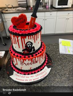 a three tiered cake with red and black icing on it's sides