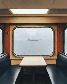 the inside of a train car with two seats and a table in front of it