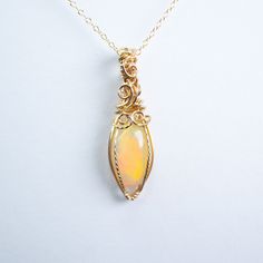 Fire Opal pendant wire wrapped by hand in 14K GOLD filled. Comes with 14K GOLD filled chain 18 inches. Formal Yellow Gold Wire Wrapped Jewelry, Elegant Hand Wrapped Round Pendant Necklace, Gold-plated Wire Wrapped Jewelry, 14k Gold-filled Wire Wrapped Necklace, Yellow Gold Wire Wrapped Pendant Jewelry, Wire Wrapped Yellow Gold Pendant Jewelry, Sterling Silver Yellow Gold Wire Wrapped Necklaces, Unique Oval 14k Gold Necklace, Elegant 14k Gold Wire Wrapped Necklace