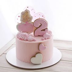 a pink birthday cake with a princess figure on top