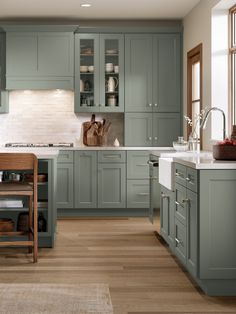 a kitchen with green cabinets and wooden floors