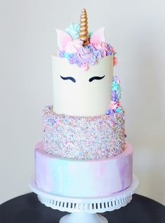 there is a cake that has a unicorn face on it and sprinkles