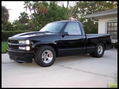 a black truck parked in front of a house