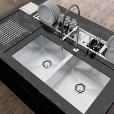 a kitchen with two sinks and plates on the counter top, next to a dishwasher