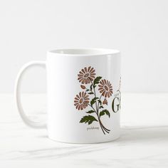 a white coffee mug with brown flowers on it