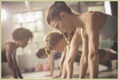 three women are doing push ups in a row on the floor with their hands together