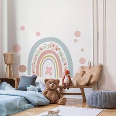 a child's bedroom decorated in pastel colors with polka dots and a rainbow wall decal