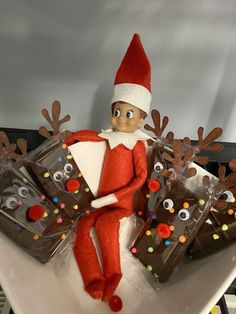 an elf is sitting on a plate with chocolate bars