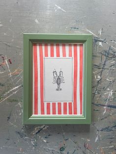 a green frame with a red and white striped pattern on it, holding an image of a crab