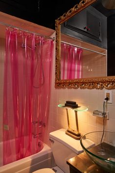 a bathroom with pink shower curtain and toilet