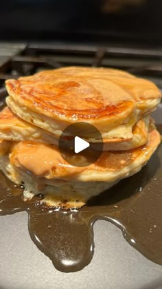 three pancakes sitting on top of a pan covered in syrup