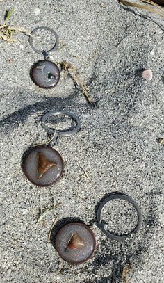 some metal rings are laying in the sand and on the ground next to rocks,