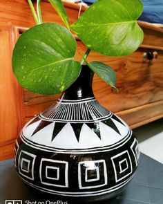 a black and white vase with a plant in it