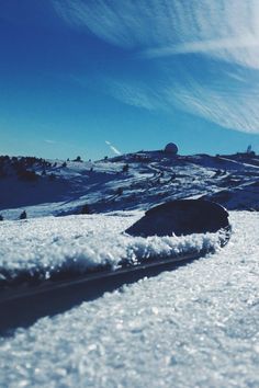 a snowboarder is going down a snowy hill