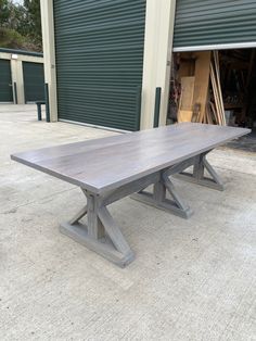 a wooden table sitting in front of a garage