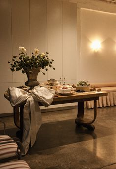 the table is set up with food and flowers in vases on it's legs