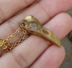 Beautiful details and delicate design make this Raven Skull Pendant very special. Antiqued gold skull dangles from gold plated chain. The subtle gold color of the bird skull and fine quality give this simple piece of jewelry an aged feel and a nice sturdiness you can feel. Truly one of my very favorite designs. A lovely pair coordinating earrings are available, as well. Bird Skulls are a favorite theme of mine and you will find many other pieces of jewelry at A Cheerful Nest featuring the skulls Gold Skull Necklace For Halloween, Halloween Skull Shaped Gold Jewelry, Adjustable Gold Jewelry For Halloween, Bronze Skull-shaped Jewelry Gift, Bronze Skull Jewelry For Gifts, Bronze Skull Jewelry Gift, Bird Skulls, Bird Skull Jewelry, Raven Skull Necklace