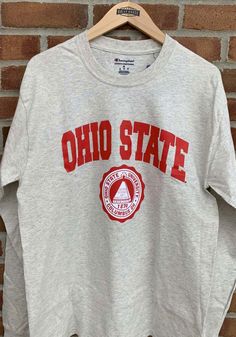 Champion Ohio State Buckeyes Oatmeal Arch Mascot Long Sleeve T Shirt - 14755698 Pre-shrunk Crew Neck Varsity T-shirt, Casual Crew T-shirt For Fan Gear, Casual Crew Neck T-shirt For Fans, Casual Gray Top For Game Day, Casual Crew T-shirt For Game Day, Athletic Heather Varsity Cotton Top, Fabric Outfits, University Tshirt, Irish Pride