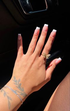 a woman's hand with white nail polish and gold ring on her left wrist