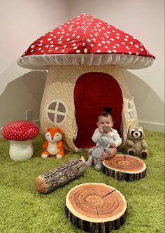 a baby sitting in front of a mushroom house