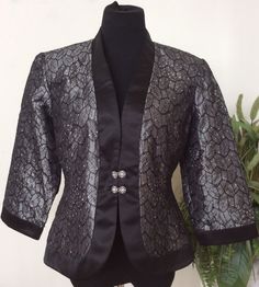 I). Beautiful glittering black nylon blend dressy jacket top that pairs perfectly with dress pants. stylish plain collars . Front pretty rhinestones closure hook. No vent opening. Black inner lining with shoulder pads for comfort. Note: all measurements are +/-2 inches. Please see and enlarge picture. Gently used and in excellent good condition. Please review measurements below for fit as each individual's fit is different. Approximate Measurements: Chest: pit to pit 42.5" (Doubled) Sleeve: shou Dressy Jacket, Dressy Jackets, Dressy Blouse, Accessory Ideas, Wedding Guest Dresses, Black Nylon, Black Nylons, Blouse Top, Guest Dresses