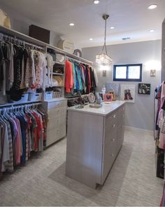 an organized closet with clothes hanging on the walls and drawers, along with other items