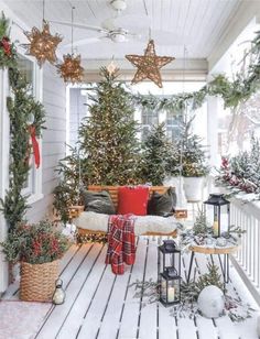 a porch covered in christmas trees and decorations