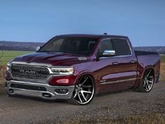 a red ram truck parked on the side of a road next to a grassy field